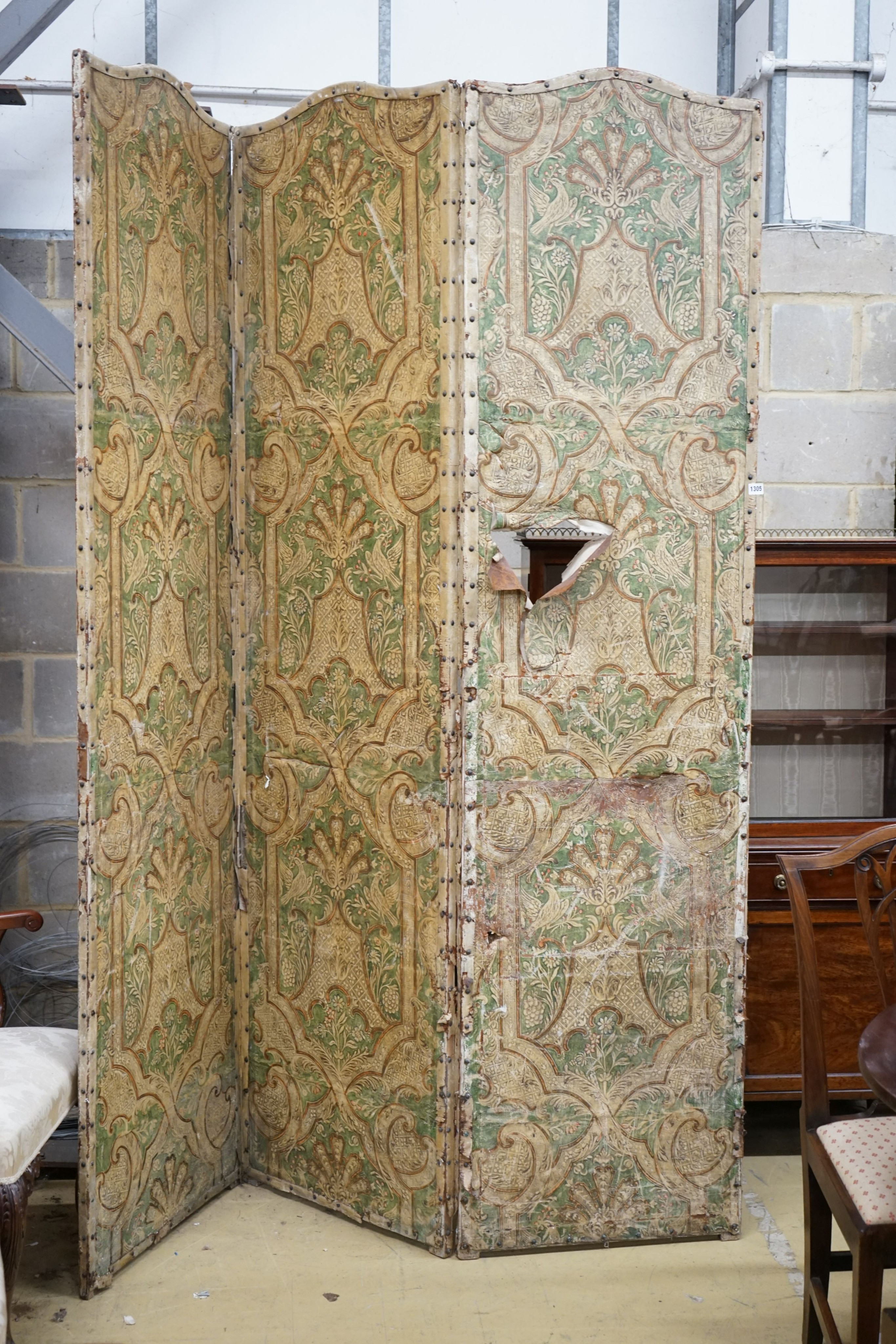 A Spanish painted leather three fold dressing screen, each panel width 60cm, height 237cm